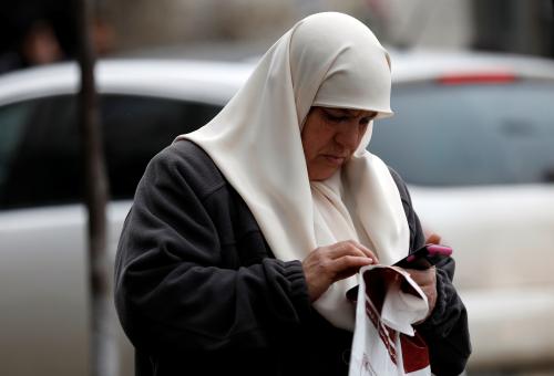 A Palestinian woman uses her mobile phone in the West Bank city of Ramallah January 24, 2018. REUTERS/Mohamad Torokman