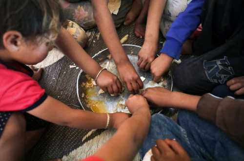 Ahmad Yassin al-Ali and Fawza Umri's children eat together inside their tent, at Atmeh camp, near the Turkish border, Syria June 13, 2020. Picture taken June 13, 2020. REUTERS/Khalil Ashawi