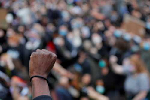 FILE PHOTO: Demonstrators raise their fists as they take a knee for 8 minutes 46 seconds, the length of time George Floyd was held down with a knee on his neck by a Minneapolis Police officer, during a protest against racial inequality in the aftermath of George Floyd's death, in Boston, Massachusetts, U.S., June 7, 2020. REUTERS/Brian Snyder/File Photo