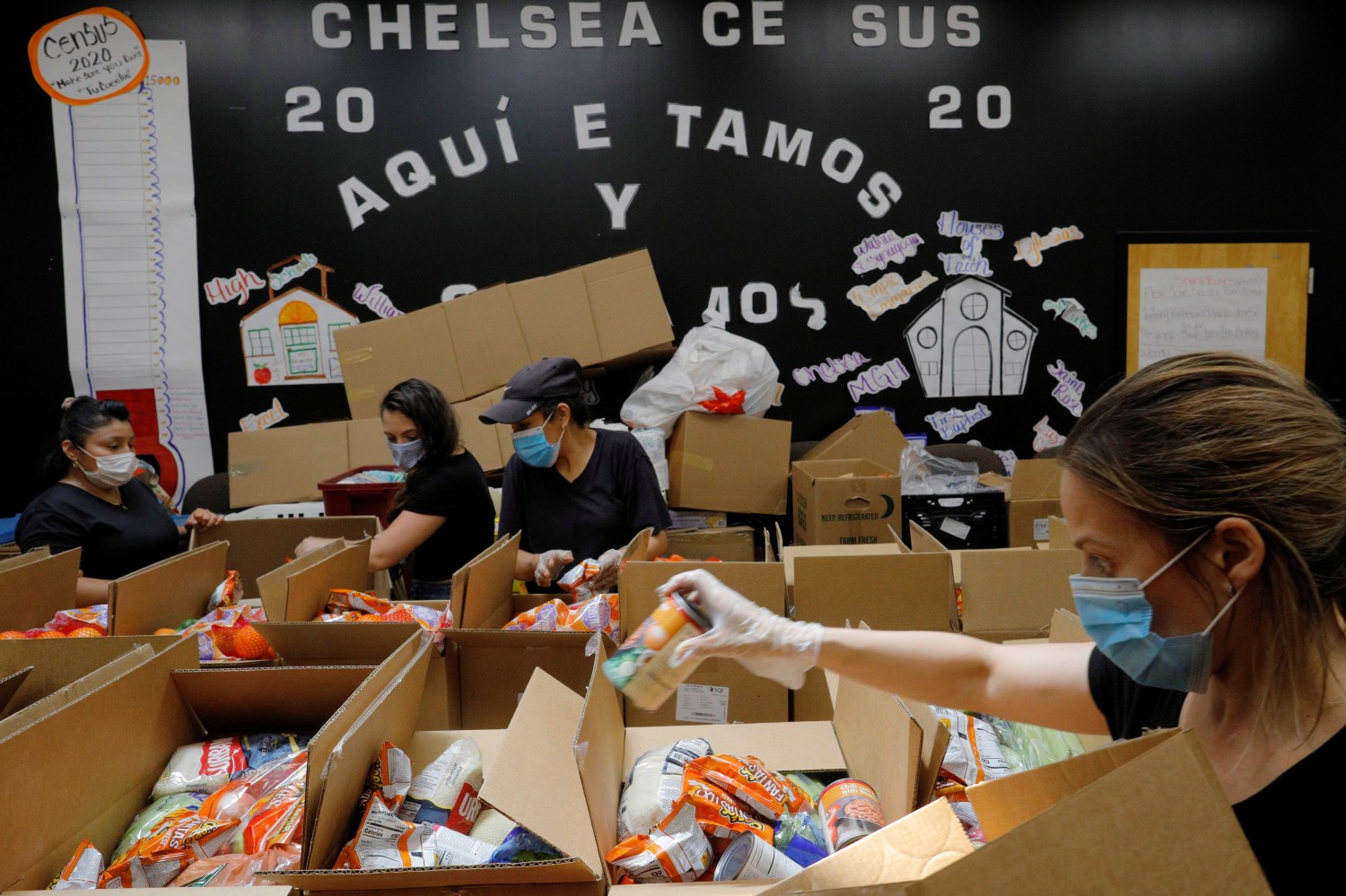 Workers prepare boxes of free food for distribution at the Chelsea Collaborative, which distributes 6 to 7 thousand of boxes of food a week in a city hard hit by the coronavirus disease (COVID-19) outbreak, in Chelsea, Massachusetts, U.S., July 9, 2020.   REUTERS/Brian Snyder