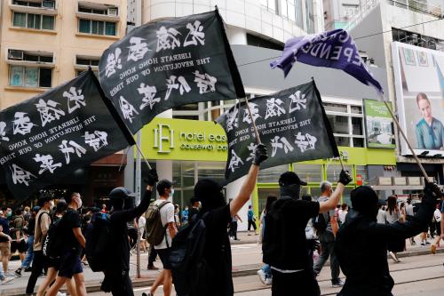 FILE PHOTO: An anti-national security law protester (R) holds a Hong Kong independence flag as he marches on the anniversary of Hong Kong's handover to China from Britain in Hong Kong, China July 1, 2020. REUTERS/Tyrone Siu/File Photo   To match Special Report HONGKONG-PROTESTS/SECURITY-POLICE