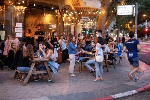 People enjoy themselves at a restaurant as some businesses reopened at the end of last month under a host of new rules, following weeks of shutdown amid the coronavirus disease (COVID-19) crisis, in Tel Aviv, Israel June 4, 2020. Picture taken June 4, 2020. REUTERS/Amir Cohen