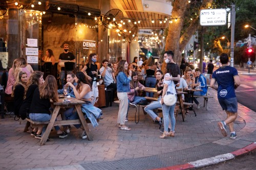 People enjoy themselves at a restaurant as some businesses reopened at the end of last month under a host of new rules, following weeks of shutdown amid the coronavirus disease (COVID-19) crisis, in Tel Aviv, Israel June 4, 2020. Picture taken June 4, 2020. REUTERS/Amir Cohen