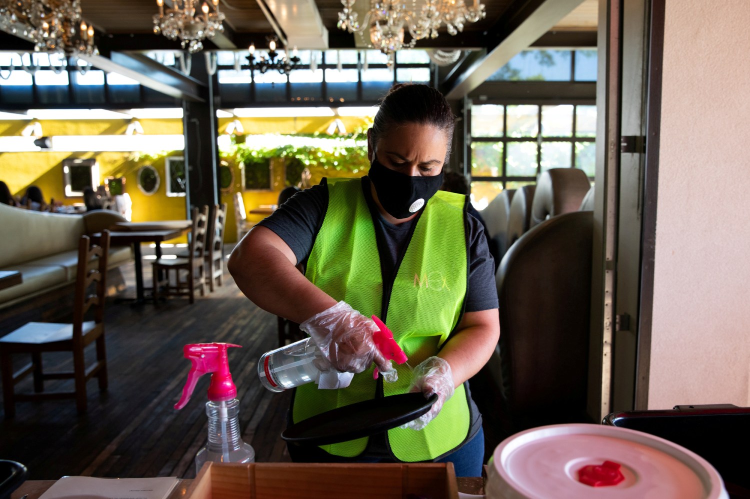 FILE PHOTO: An employee routinely sanitizes server trays at a reopened restaurant after restrictions to prevent the spread of the coronavirus disease (COVID-19) are eased in Bloomfield Hills, Michigan, U.S., June 8, 2020.  REUTERS/Emily Elconin/File Photo
