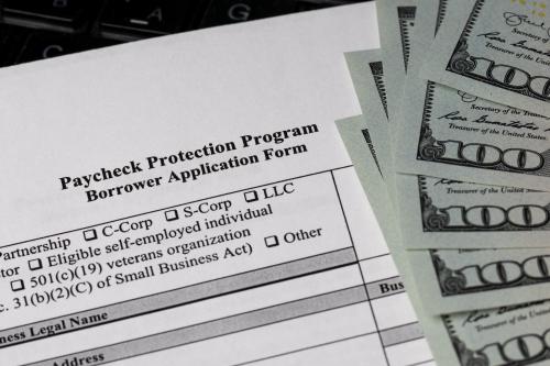 Paycheck Protection Program application and hundred dollar bills.