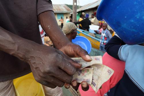 Unidentified fisherman counting money and trading fish on December 24, 2014 in a traditional fishing village at Lake Victoria, Kenya