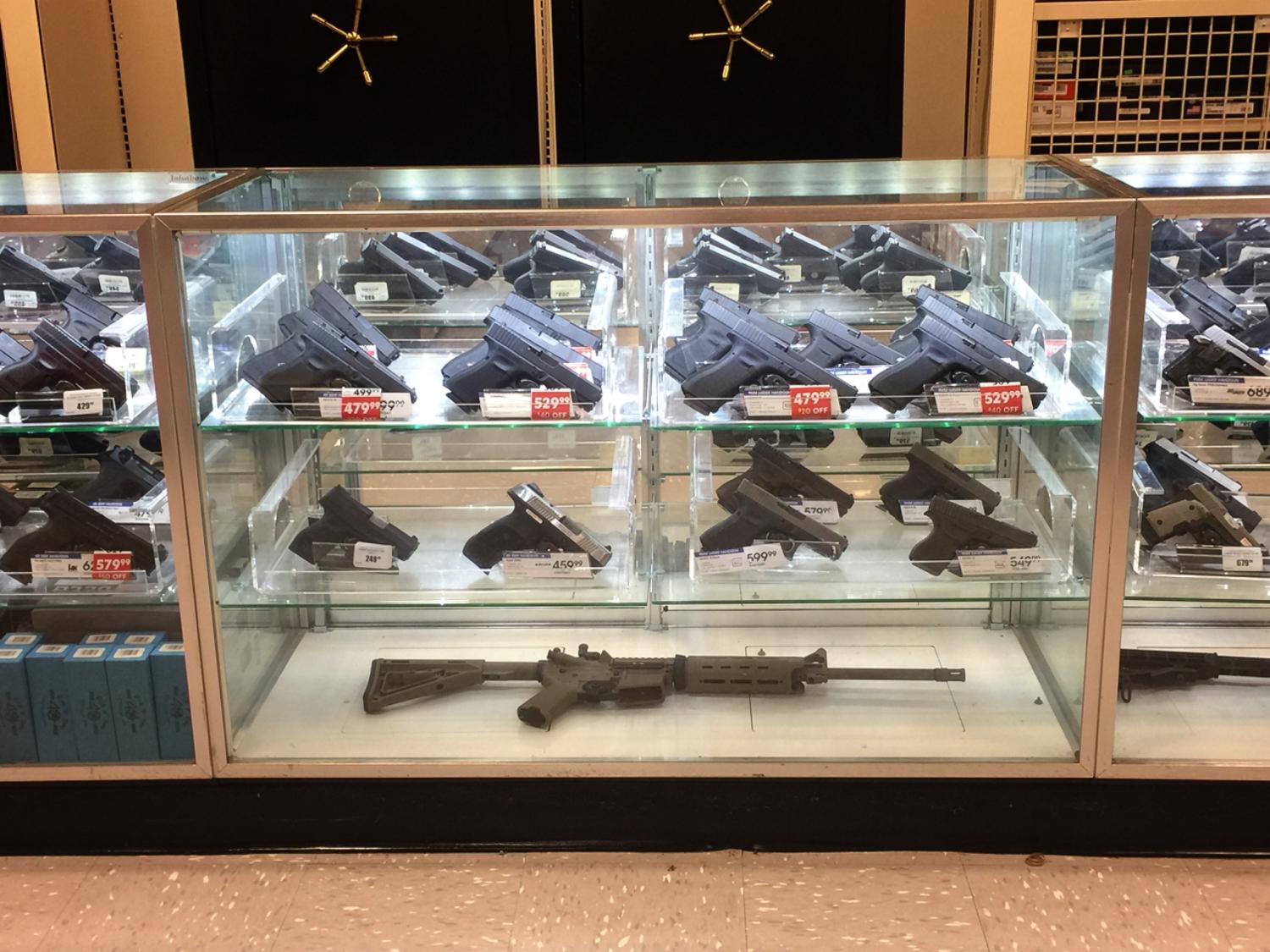 Display case filled with different types of guns for sale.