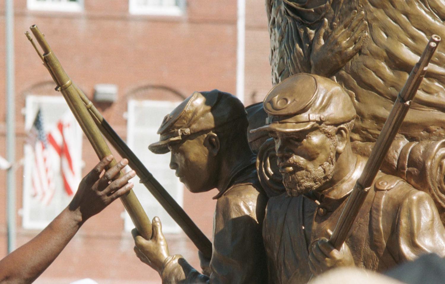 A person reaches up to touch the "Spirit of Freedom" Memorial just after its unveiling July 18. The statue honors the more than 200,000 African-American soldiers who fought, and the more than 37,000 who died, during the Civil War.RC/vm/AA