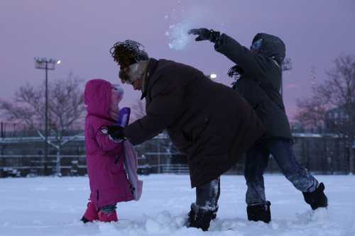 A boy throws snow at his mother as they play in a playground in Harlem, New York, U.S. February 9, 2017. REUTERS/Bria Webb