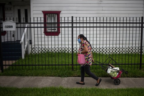 Antonia, 62, walks home with groceries distributed by the Wesley Community Center to residents affected by the economic fallout caused by the coronavirus disease (COVID-19) outbreak in Houston, Texas, U.S., July 24, 2020. REUTERS/Adrees Latif