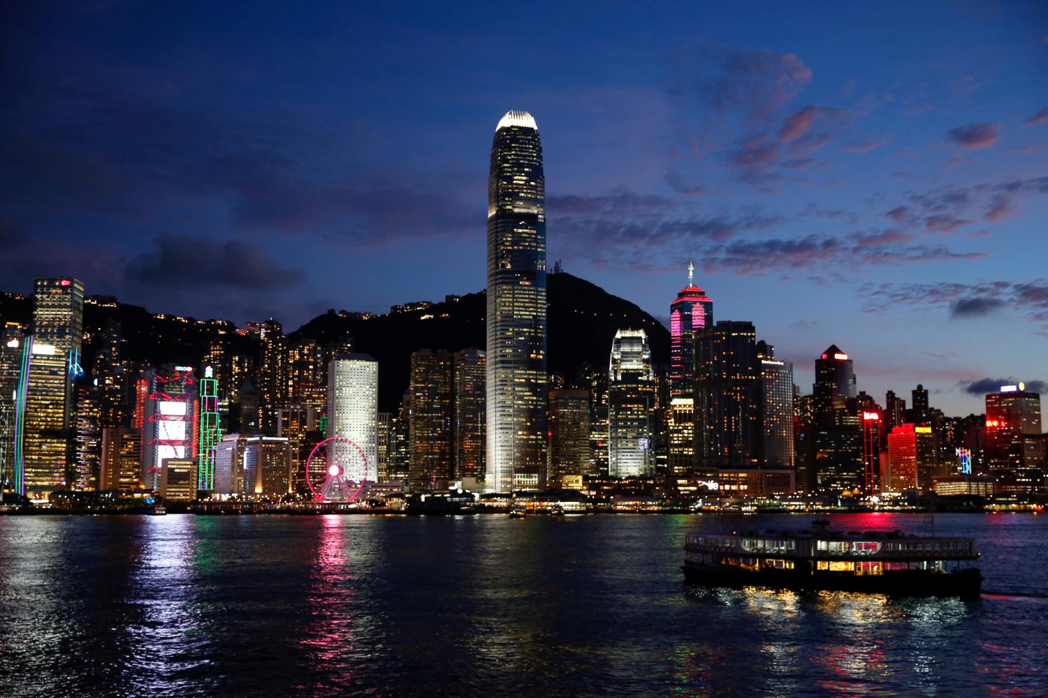 FILE PHOTO: A Star Ferry boat crosses Victoria Harbour in front of a skyline of buildings during sunset in Hong Kong, China June 29, 2020. REUTERS/Tyrone Siu/File Photo