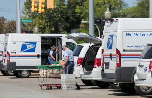 United States Postal Service (USPS) workers load mail into delivery trucks outside a post office in Royal Oak, Michigan, U.S. August 22, 2020. REUTERS/Rebecca Cook