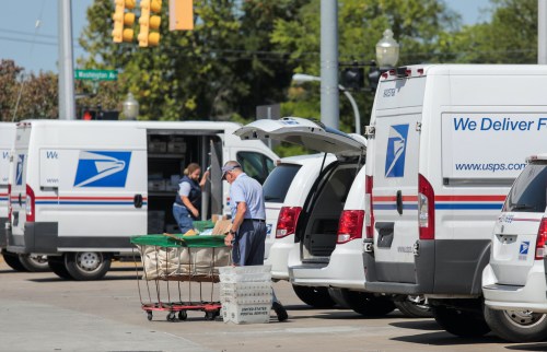 United States Postal Service (USPS) workers load mail into delivery trucks outside a post office in Royal Oak, Michigan, U.S. August 22, 2020. REUTERS/Rebecca Cook