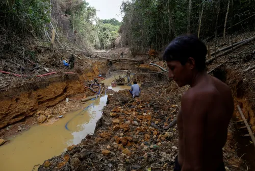 A Yanomami indian follows agents of Brazil's environmental agency in a gold mine during an operation against illegal gold mining on indigenous land, in the heart of the Amazon rainforest, in Roraima state, Brazil April 17, 2016. Picture taken April 17, 2016. REUTERS/Bruno Kelly