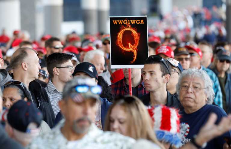 A man in the crowd holds a QAnon sign with the group's abbreviation of their rallying cry "Where we go one, we go all" as crowds gather to attend U.S. President Donald Trump's campaign rally at the Las Vegas Convention Center in Las Vegas, Nevada, U.S., February 21, 2020. REUTERS/Patrick Fallon