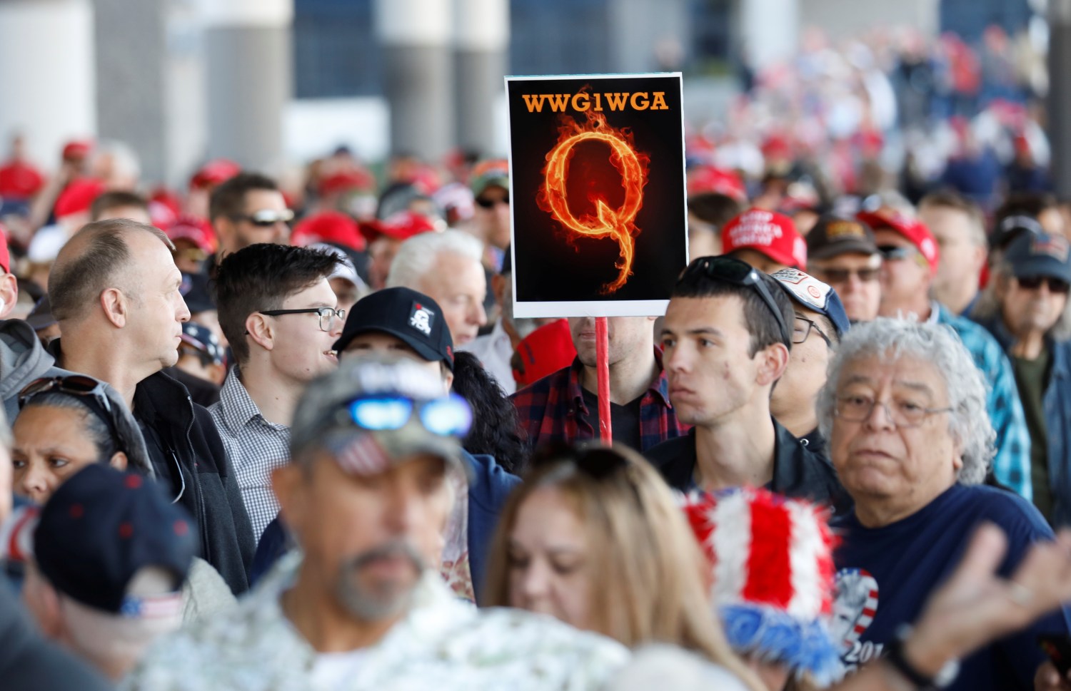 A man in the crowd holds a QAnon sign with the group's abbreviation of their rallying cry "Where we go one, we go all" as crowds gather to attend U.S. President Donald Trump's campaign rally at the Las Vegas Convention Center in Las Vegas, Nevada, U.S., February 21, 2020. REUTERS/Patrick Fallon