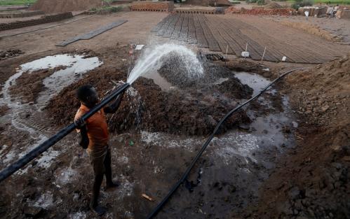 Zaki El-Dine, 24, a brick-maker, pours water from the Nile river onto a patch of mud to make bricks on Tuti Island, Khartoum, Sudan, February 12, 2020. REUTERS/Zohra Bensemra     SEARCH "BENSEMRA NILE" FOR THIS STORY. SEARCH "WIDER IMAGE" FOR ALL STORIES.