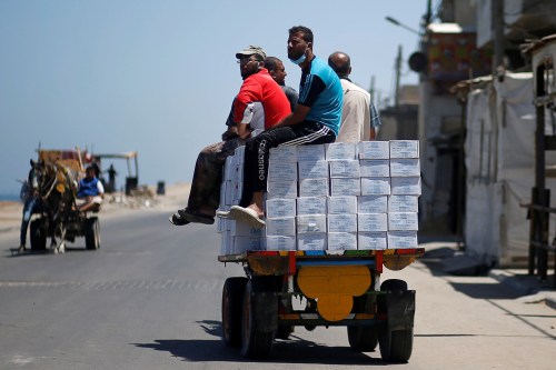 Palestinians ride a horse-drawn cart transporting aid supplies distributed by UNRWA at Beach refugee camp amid the coronavirus disease (COVID-19) crisis, in Gaza City June 1, 2020. REUTERS/Mohammed Salem