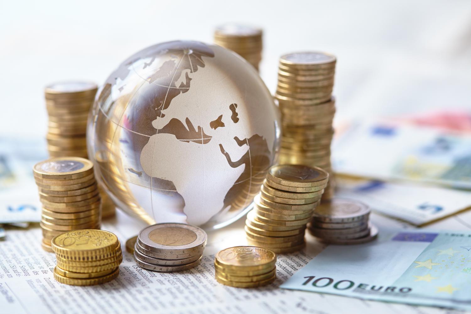 Globe surrounded by stacks of coins