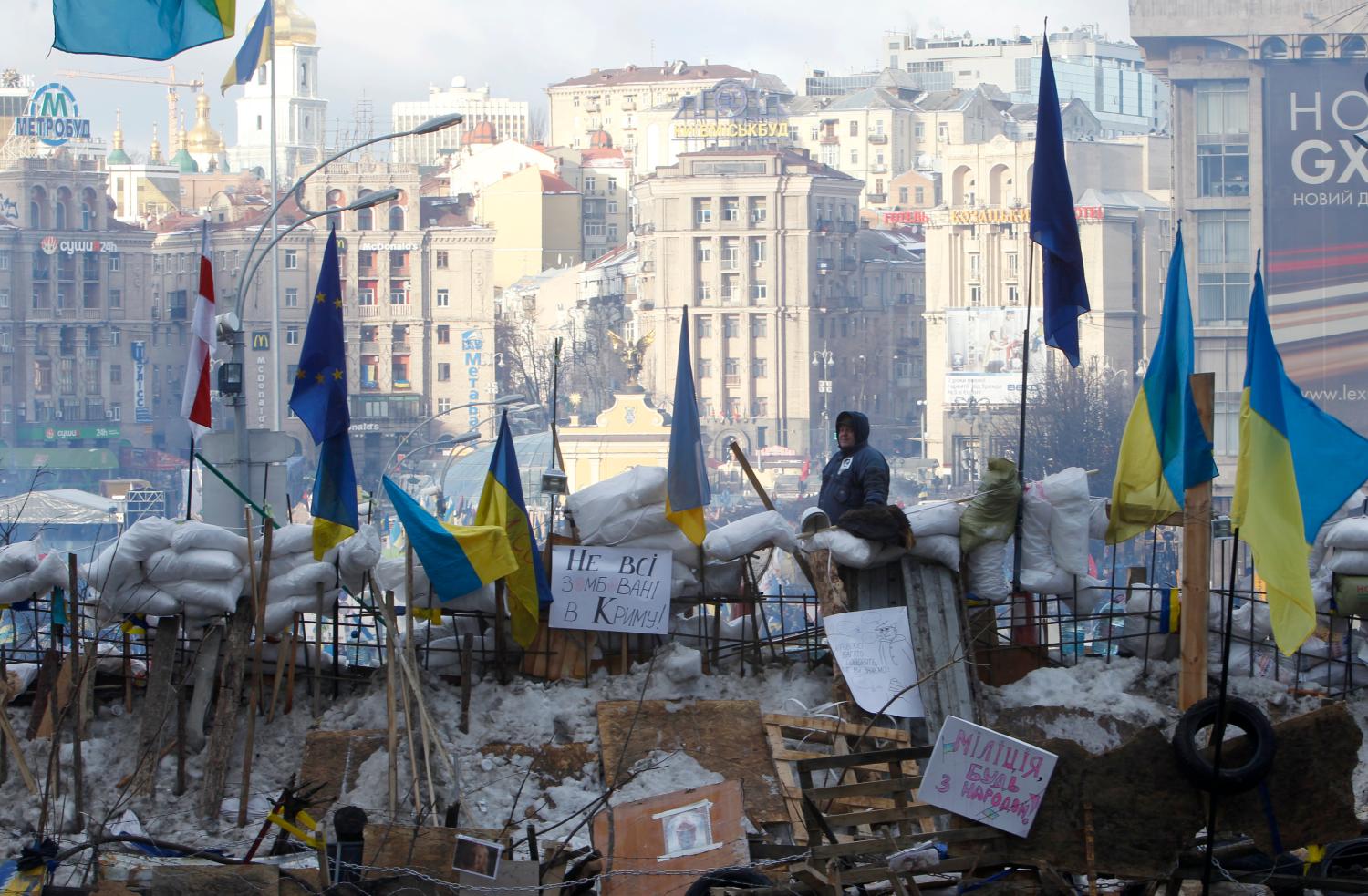 A pro-European integration protester looks out from a barricade on Independence Square in Kiev on December 14, 2013.