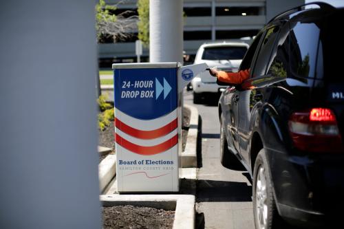 Voters place ballots in a 24-hour drop box at the Hamilton County Board of Elections in Norwood, Ohio, on Monday, April 27, 2020. The Board of Elections is taking ballots through the drive through drop box and by mail as the April 28 deadline approaches.Board Of Elections Drop Box