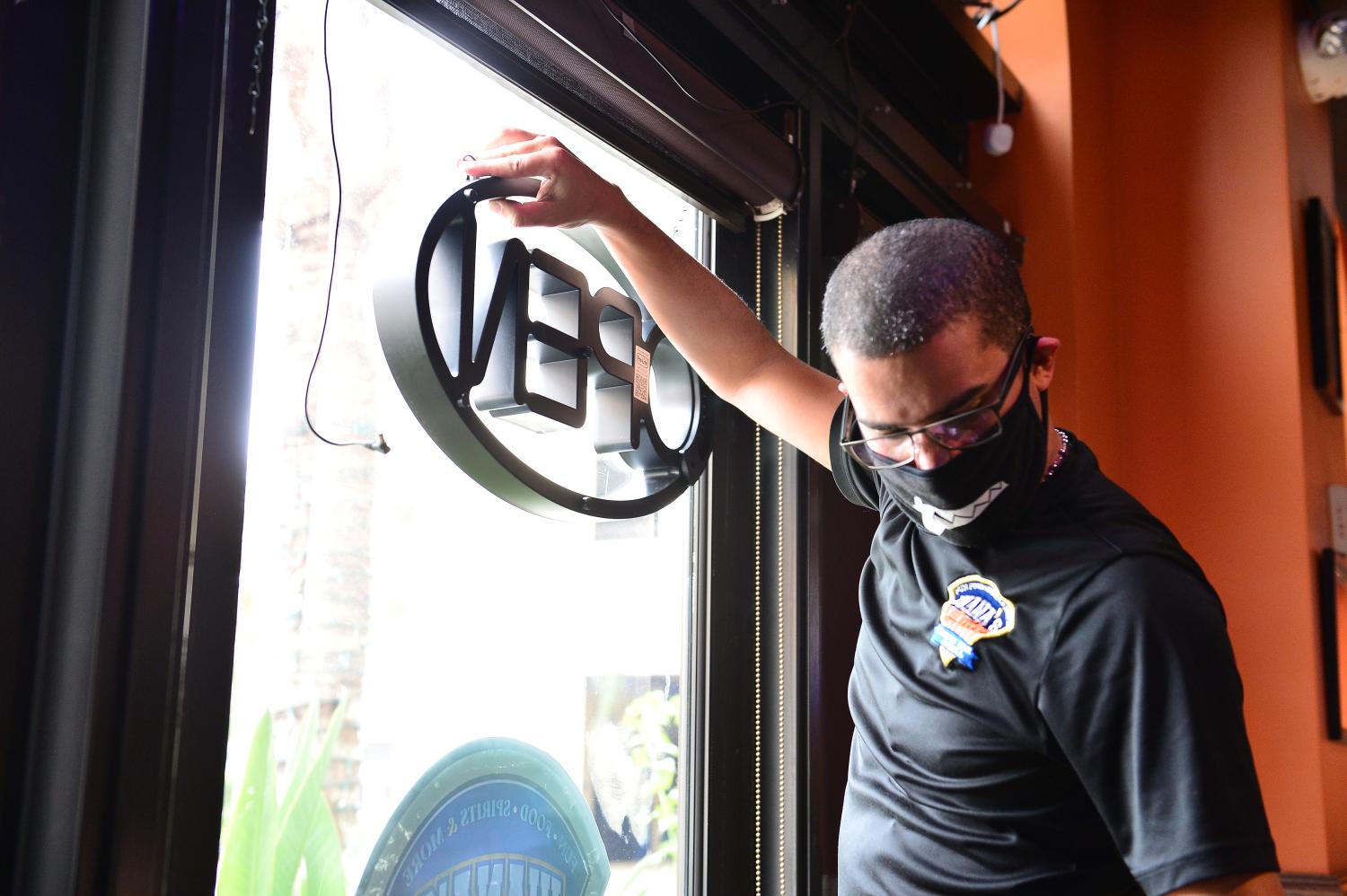Juana's Latin Sports Bar & Grill employee seen hanging the open sign for re-opens for indoor dining on May 18, 2020 in Miramar, Florida. The six year old family own restaurant with 30 plus employee re-opened approximately two months after shutting it's doors due to the coronavirus pandemic and lost over $300,000 of revenue during that time. Juana's Latin Sports Bar & Grill just received a PPP loan approval on May 6 and looking for most of they employee to come back to work. as Broward County starts the first phase of the states coronavirus pandemic re-opening plan, which includes openings with certain restrictions of businesses like barber shops, hair salon, restaurants and retail stores. (Photo by JL/Sipa USA)No Use UK. No Use Germany.