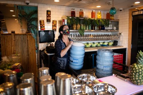 Bartender Nicole DeVito restocks the outdoor bar at Farmers Fishers Bakers, a restaurant on the Georgetown Waterfront in Washington, D.C., on May 29, 2020 amid the Coronavirus pandemic. After shifting metrics for reopening in recent weeks, today the District of Columbia began the first stage of economic reopening allowing restaurants and other business to operate in limited capacity despite the COVID-19 outbreak. (Graeme Sloan/Sipa USA)No Use UK. No Use Germany.