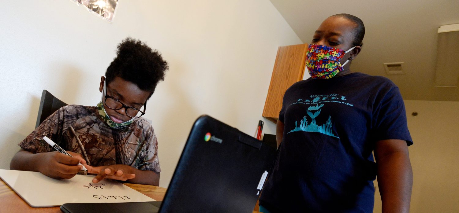 Malik Gordon, a sixth grader at Nashville Classical Charter School, sits with his mother, Victoria, as he does online learning on Thursday, Aug. 20, 2020. Victoria Gordon had to quit her job to support him academically, but they are still experiencing challenges with virtual schooling.Nas Remote Learning Inequities 003 1