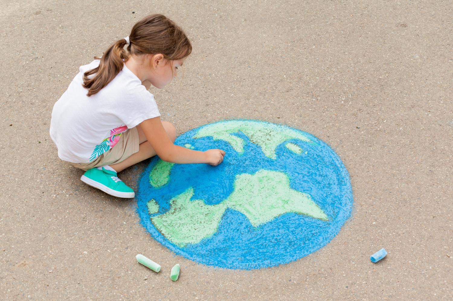 Girl draws the Earth using chalk