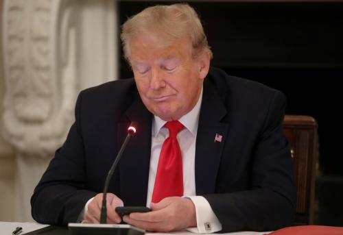 U.S. President Donald Trump is using a mobile phone during a roundtable discussion on the reopening of small businesses in the State Dining Room at the White House in Washington, U.S., June 18, 2020.