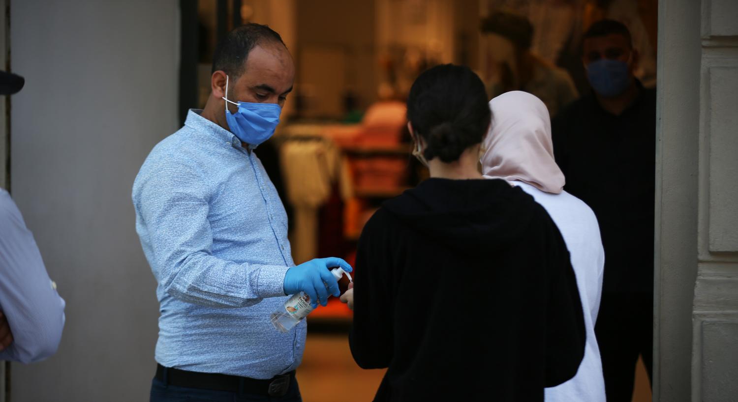 Shop agent use handgel for clients during the first opning of the shops after the lockdown in Tunis, Tunisia on May 11, 2020. With the health ban in its first phase (from 4 to 24 May) entering its second week, the commercial movement in the capital resumed its activity in a significant and significant way by recovering the activity of selling ready-made clothes and shoes and the rest of the other commercial activities. Since the early hours of Monday morning, most shops selling ready-made clothes and shoes have opened their doors to the public amid strict precautions to prevent the spread of the new Coronavirus (COVID-19), despite Tunisia's relative control of this global pandemic. (Photo by Mohamed Krit/ Sipa USA)No Use UK. No Use Germany.