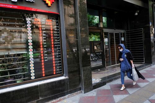 An Iranian woman wears a protective face mask as she walks next to an electronic currency board in Tehran, Iran July 2, 2020. Picture taken July 2, 2020. Mohamadreza Nadimi/WANA (West Asia News Agency) via REUTERS ATTENTION EDITORS - THIS PICTURE WAS PROVIDED BY A THIRD PARTY