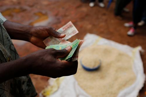 A Malawian trader counts money as he sells maize near the capital Lilongwe, Malawi February 1, 2016. Floods and an El Nino-triggered drought have hit the staple maize crop, exposing the fragility of Malawi's progress, which was partly rooted in a fertiliser grant for small-scale farmers that the government, now starved of donor funds, can ill afford. Picture taken February 1, 2016. To match Insight AFRICA-DROUGHT/MALAWI. REUTERS/Mike Hutchings