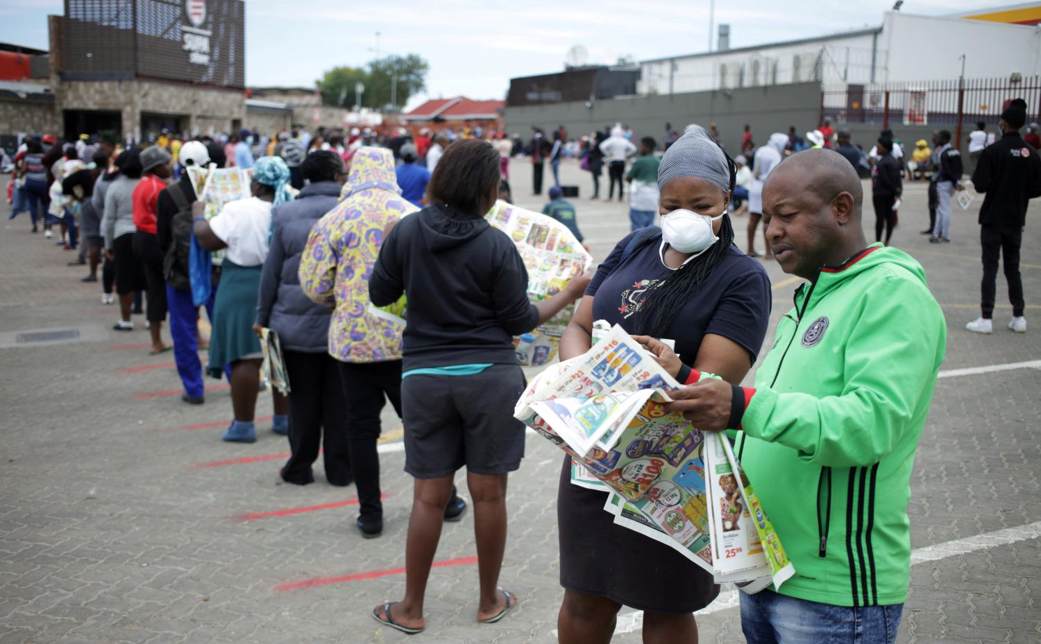 FILE PHOTO: Shoppers queue outside a grocery store during a 21 day nationwide lockdown, aimed at limiting the spread of coronavirus disease (COVID-19) in Soweto, South Africa, March 30, 2020. REUTERS/Siphiwe Sibeko/File Photo