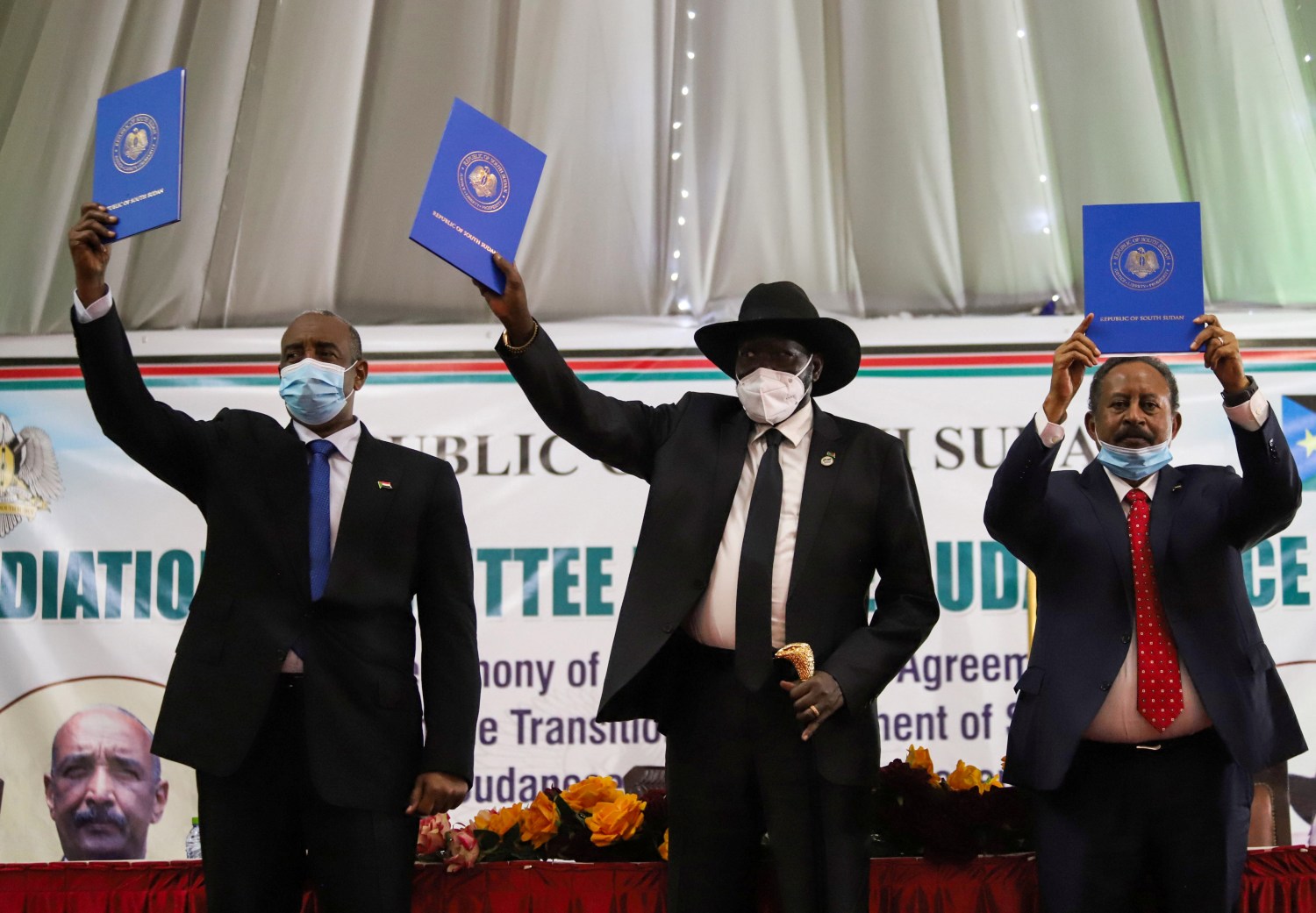 Sudan's Sovereign Council Chief General Abdel Fattah al-Burhan, South Sudan's President Salva Kiir, and Sudan's Prime Minister Abdalla Hamdok lift copies of a signed peace agreement with the country's five key rebel groups, a significant step towards resolving deep-rooted conflicts that raged under former leader Omar al-Bashir, in Juba, South Sudan August 31, 2020. REUTERS/Samir Bol
