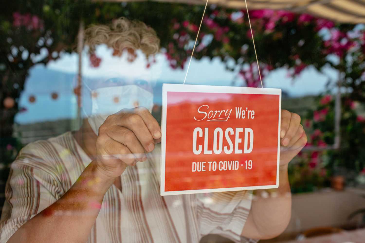 Business Owner With Face Mask Putting Closed Sign