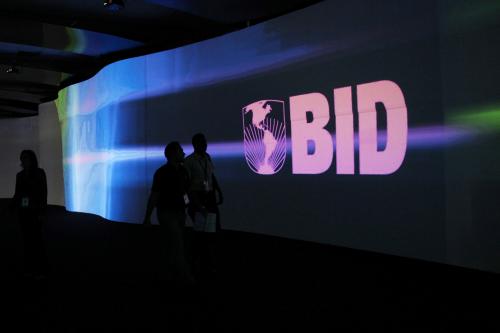 FILE PHOTO: Visitors walk past a screen with the logo of Banco Interamericano de Desarrollo (BID), also known as the Inter-American Development Bank, at the Atlapa Convention Center in Panama City March 13, 2013. REUTERS/Carlos Jasso/File Photo