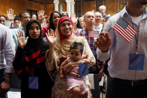 New citizens stand during the Pledge of Allegiance at the U.S. Citizenship and Immigration Services (USCIS) naturalization ceremony at the New York Public Library in Manhattan, New York, U.S., July 3, 2018.  REUTERS/Shannon Stapleton