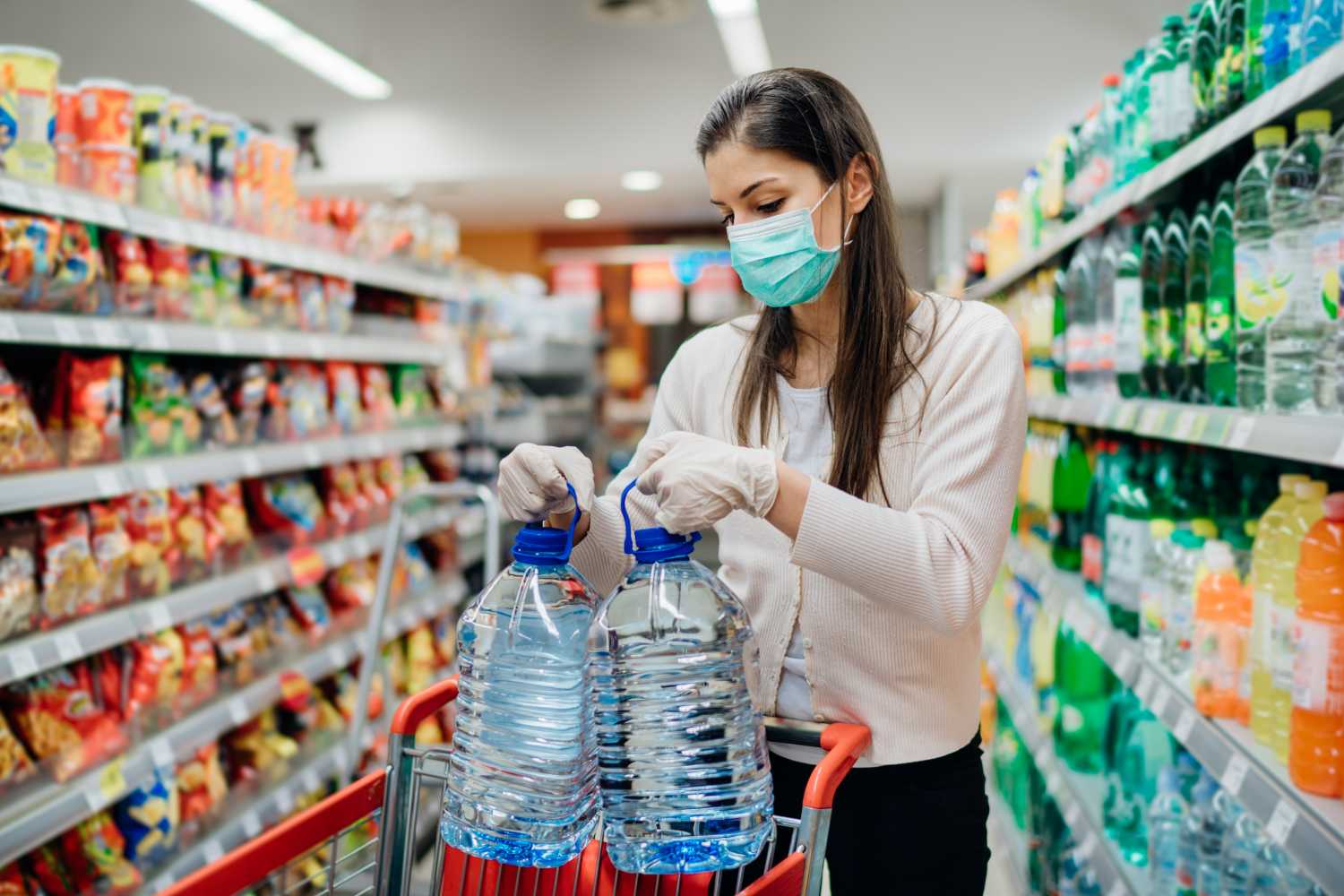 Buyer wearing a protective mask.Shopping during the pandemic.Emergency to buy list.Water supplies shortage.Panic buying during coronavirus outbreak.Preparation for a pandemic quarantine