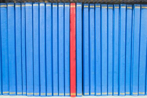 Book in a bookshelf standing out at university library.