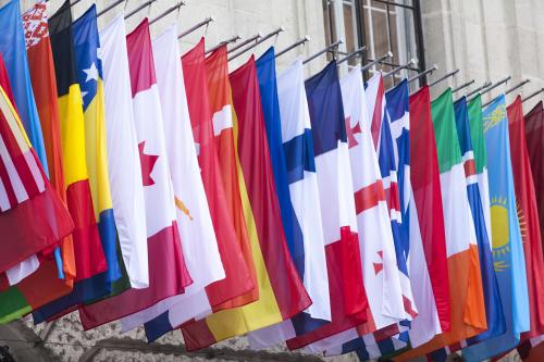 Numerous national flags hang outside a building.