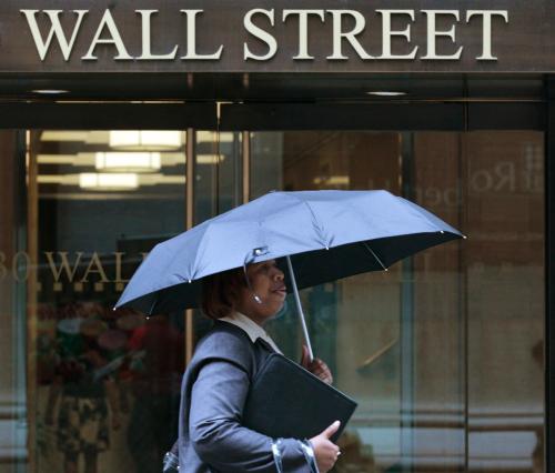 A woman walks through the rain on Wall Street in New York, August 16, 2011. REUTERS/Brendan McDermid (UNITED STATES - Tags: BUSINESS)