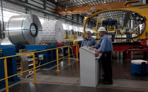 Severstal North America steel workers stand by the operating station for shrink wrapping steel coils in the Severstal steel mill in Dearborn, Michigan.