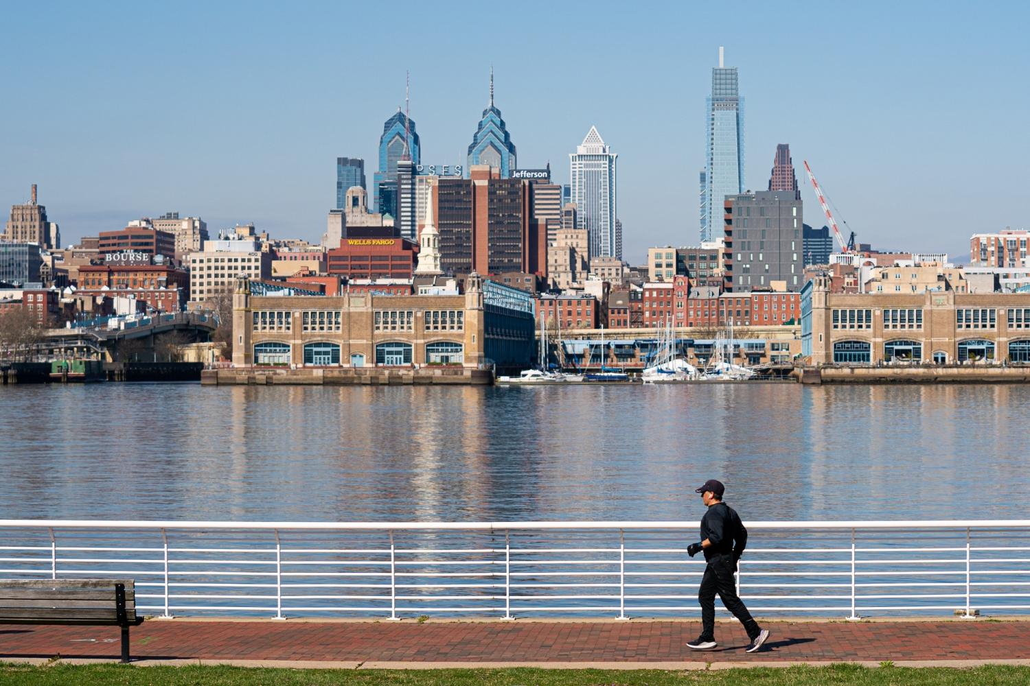 Mar 26, 2020; Philadelphia, PA, USA; A jogger runs along a river path in Camden NJ with the Philadelphia skyline in the background. Mandatory Credit: Bill Streicher-USA TODAY NETWORK