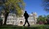 A man walks at an empty campus green at Georgetown University, closed weeks ago due to coronavirus, in Washington, U.S., April 3, 2020. REUTERS/Kevin Lamarque