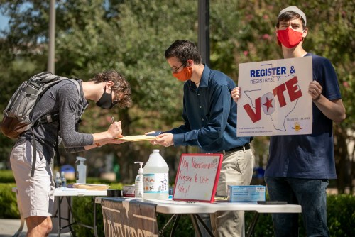 Oct 5, 2020; Austin, TX, USA; Deputy voter registrars Brandon Bradley, 19, middle, and Jacob Turner, 20, help Jonathan Geymer, 19, left, register to vote at a voter registration drive on the University of Texas campus on Monday October 5, 2020.  Monday is the deadline to register to vote in Texas in the Nov. 3 local and national elections, including the races for president; congressional and legislative seats; governor; lieutenant governor; and city and county government and judicial posts.  Mandatory Credit: Jay Janner-USA TODAY NETWORK