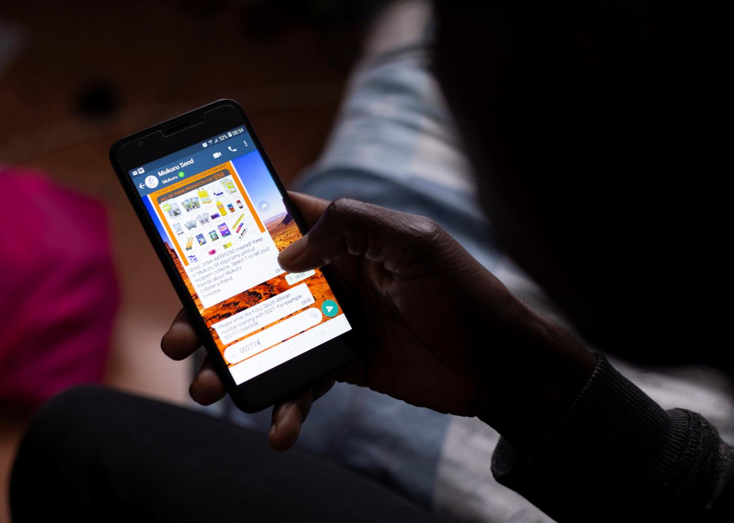 Brighton Takawira uses the Mukuru remittance app which enables him to send money and groceries home to family in Zimbabwe from his home in Pinetown, South Africa, October 21, 2020. REUTERS/Rogan Ward