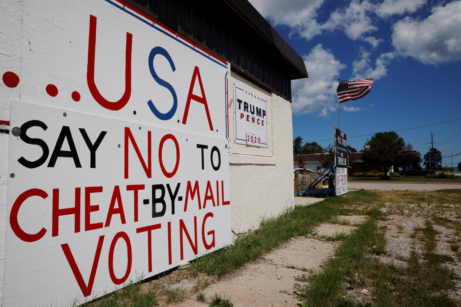 Handmade signs supporting U.S. President Donald Trump, including one opposing mail-in voting, stand outside a business in Manitowoc, Wisconsin, U.S., August 18, 2020. REUTERS/Brian Snyder