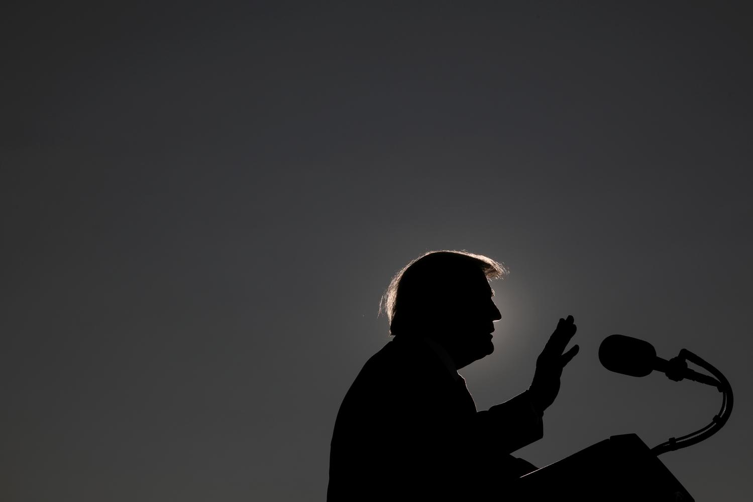 U.S. President Donald Trump is silhouetted as he delivers a speech while campaigning at Dayton International Airport in Dayton, Ohio, U.S., September 21, 2020. REUTERS/Tom Brenner