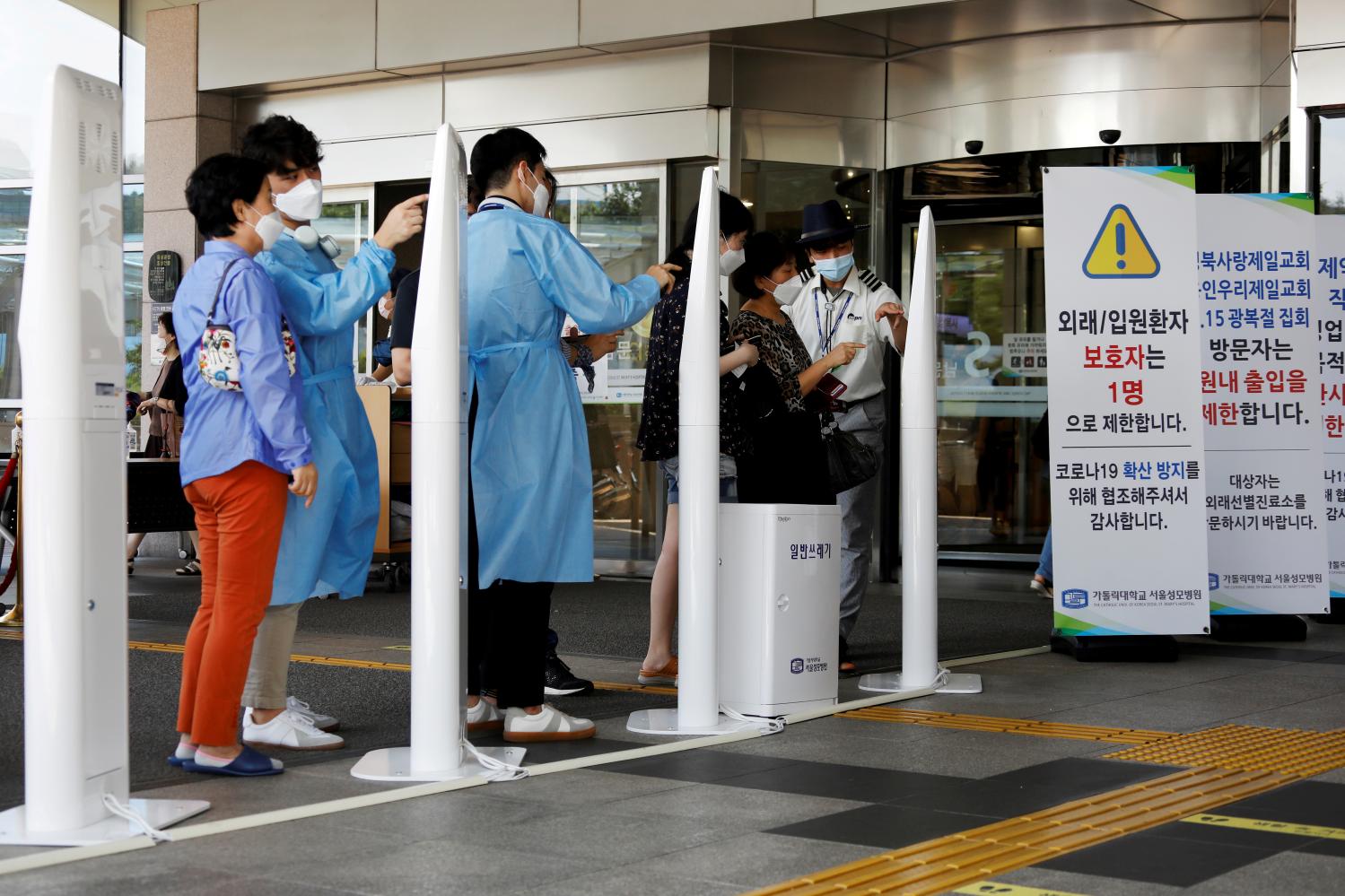 FILE PHOTO: FILE PHOTO: Visitors wearing masks to avoid the spread of COVID-19 fill out a form which is mandatory to get into a hospital in Seoul, South Korea, August 26, 2020.  REUTERS/Kim Hong-Ji